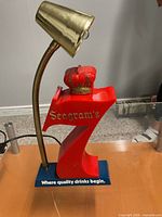 Full view of Seagram's 7 Crown lamp showing red 7 body, crown, blue base, brass-tone gooseneck and shade