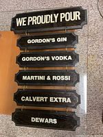 Full view of wooden bar sign showing all six plaques and brass rings
