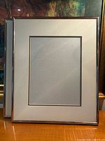 Front view of both metal frames showing mats and glass