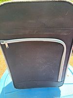 Front view of black soft-sided suitcase showing overall design and front pocket