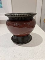 front view of burgundy ceramic candle holder with bronze-tone rim and base