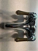 Top view of chrome faucet with two brass-accent handles