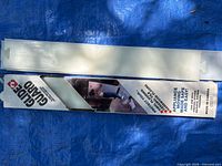Boxed and unboxed white plastic Glide Guard floor protector visible