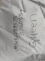 Close-up of fabric with handwritten 'Queen' marking