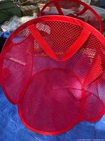 Front view of red mesh hamper showing mesh material and handle