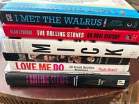 Stacked spines showing five books including I Met The Walrus, Rolling Stones An Oral History, Mick, Love Me Do, The Rolling Stones