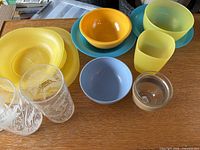 Group view of plastic plates, bowls, tumblers, glass bowl and tumblers
