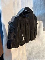 Full view of black Nike baseball glove showing exterior, stitching and swoosh logo
