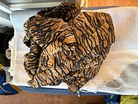 Folded tan and black animal print vacuum hose cover on surface