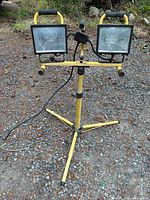 Front view showing twin halogen heads, tripod, power cord