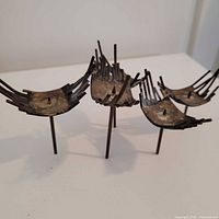 Front angled view showing four dish arms, staggered legs, spiked design
