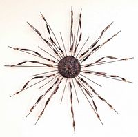 Full view of metal starburst sculpture mounted on wall