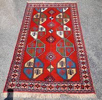 Full view of red Caucasian Erivan style rug showing pattern and fringe