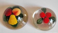 Both lucite paperweights side by side showing contents