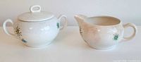Front view of lidded sugar bowl and creamer showing design and shape