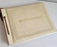 Front angled view of cream Springfield photo album showing embossed cover and cord binding
