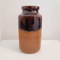 Front view of cylindrical Scheurich vase showing brown drip over caramel glaze