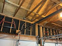 Two bow saws mounted on garage wall showing wooden frames and blades