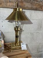 Full view of brass table lamp on wooden surface