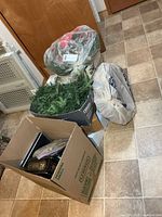 Boxes and bags holding wreaths, garland and other decorations