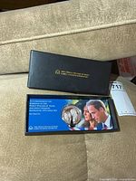 Closed black presentation box with gold lettering on lid and sleeve visible