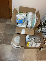 Box with various disposable dinnerware items visible