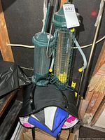 Overall view of two bird feeders hanging with stack of reusable bags beneath