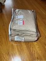 Bagged beige quilted covers showing labels and quilting detail