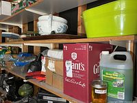Overall view of two shelves showing planter, cleaner, garden tools, lamp oil, ropes