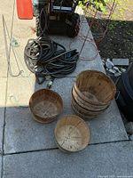 Lot overview showing hoses, tomato cages, baskets