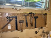 Pegboard with five hammers and two squares displayed