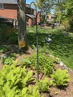 Full view of shepherd hooks assembled in garden with both glass ornaments attached
