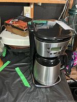 Front angled view showing Black+Decker coffee maker, boxed chicken roaster and electric frying pan