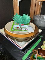 Stack showing holly leaf dish, holiday tray, chargers, square platter, grey bowl