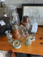 Group of all oil lamps and spare chimney on table