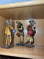 All three papier-mâché figurines on shelf