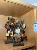 All three paper mâché figurines on shelf