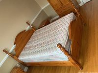 Full view of pine queen bed frame with headboard, footboard, posts, side rails