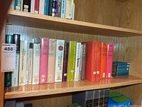 Shelf of assorted hardcover Bible commentaries with library stickers