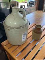Large beige jug and small brown crock on wooden slatted surface