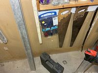 Group showing level, drill bit case, two panel saws, cordless drill case