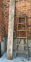 Full view of ladder and barn board leaning against wall