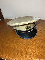 Front view of khaki National Parks Canada peaked cap with badge and black visor