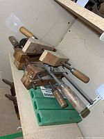 Group of three wooden clamps stacked with kneeling pad below