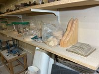 Wide view of shelf showing jars of wooden plugs, bags of wood blanks, corbels, rosette