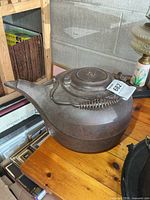 Side view of large cast iron kettle on wooden table