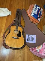 Yamaha acoustic guitar inside open hard case with attached strap