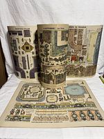 All four paper model sheets displayed, two upright, one rolled, one flat
