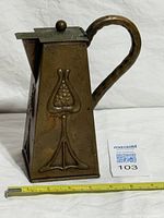 Full view of copper teapot jug left side with tulip motif and measurement tape