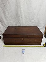 Closed mahogany box front view with measuring tape